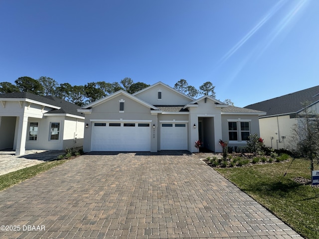 ranch-style house with decorative driveway, a garage, and stucco siding