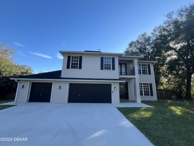 view of front of property with a front yard, a balcony, and a garage