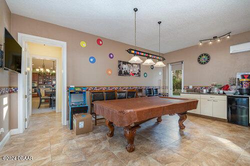 rec room with a textured ceiling, a notable chandelier, and pool table