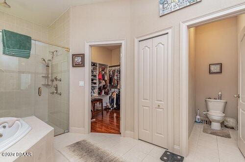 bathroom with tile patterned floors, separate shower and tub, and toilet