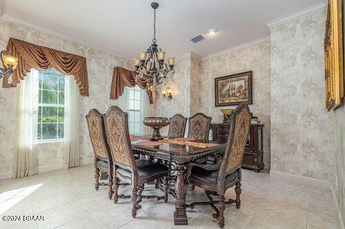 dining area with ornamental molding, light tile patterned floors, and a chandelier