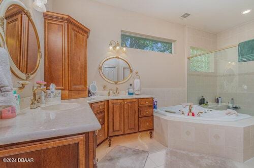 bathroom featuring tile patterned flooring, vanity, and shower with separate bathtub