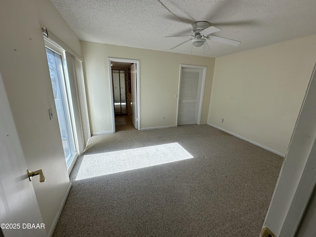 4150 S Atlantic Ave Unit 102B, New Smyrna Beach, FL 32169 - unfurnished bedroom featuring carpet floors, a textured ceiling, ceiling fan, and connected bathroom