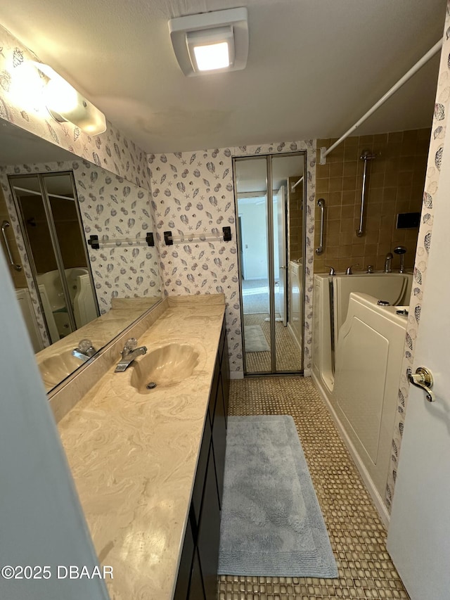 4150 S Atlantic Ave Unit 102B, New Smyrna Beach, FL 32169 - bathroom featuring vanity, wallpapered walls, and shower / bath combination with glass door