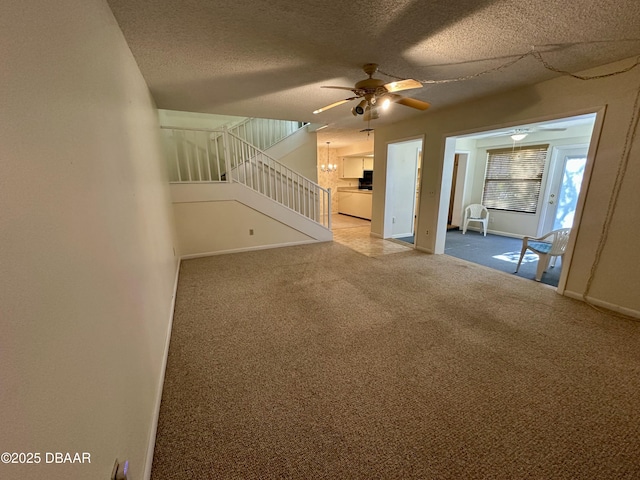 4150 S Atlantic Ave Unit 102B, New Smyrna Beach, FL 32169 - unfurnished living room featuring ceiling fan, carpet floors, stairs, and a textured ceiling