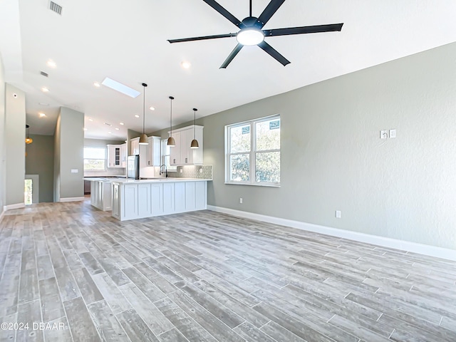 154 Capri Dr, Ormond Beach, FL 32176 - kitchen with ceiling fan, an island with sink, decorative light fixtures, and light hardwood / wood-style floors