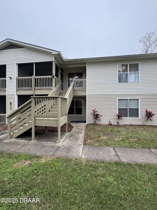 view of front facade with stairway and a front yard