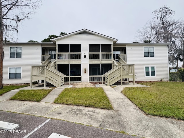 exterior space featuring stairway and a front yard