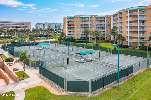 view of tennis court featuring a yard