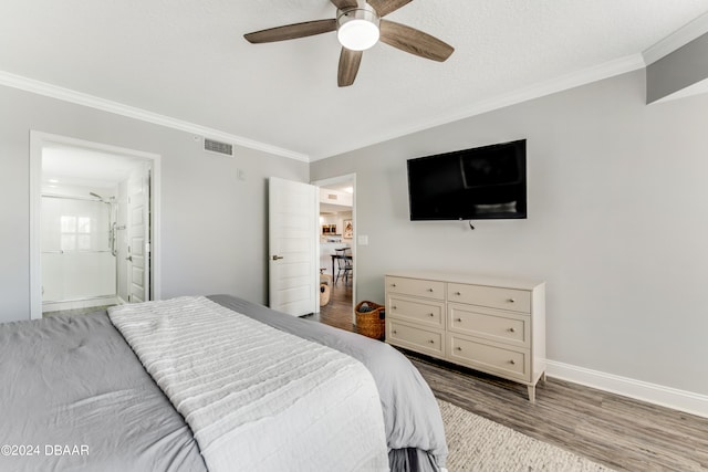 bedroom with hardwood / wood-style floors, ceiling fan, connected bathroom, and crown molding