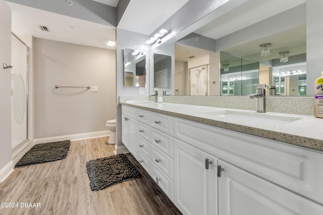 bathroom featuring walk in shower, wood-type flooring, vanity, and toilet