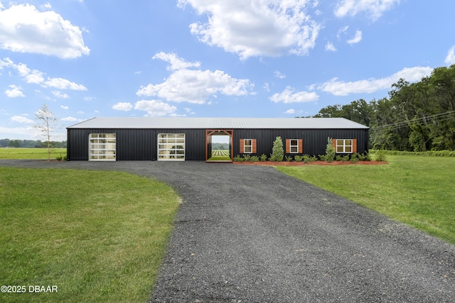 view of front of home featuring an outbuilding, a garage, and a front lawn