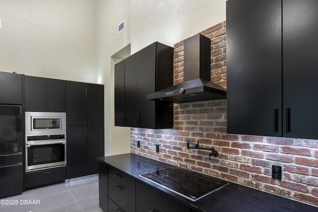 kitchen featuring light tile patterned flooring, appliances with stainless steel finishes, and wall chimney range hood