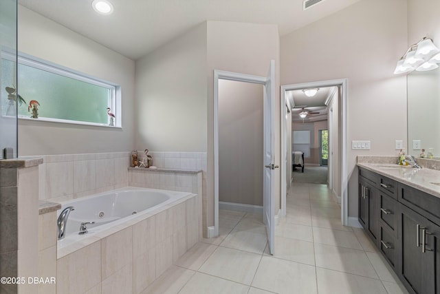 bathroom featuring a tub with jets, tile patterned flooring, vanity, a ceiling fan, and baseboards