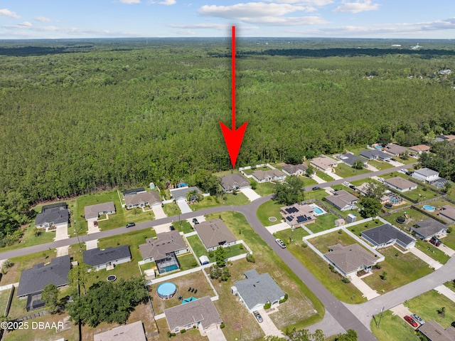 view of property location with a forest and nearby suburban area
