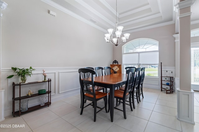 dining space with ornate columns, a decorative wall, wainscoting, a chandelier, and ornamental molding