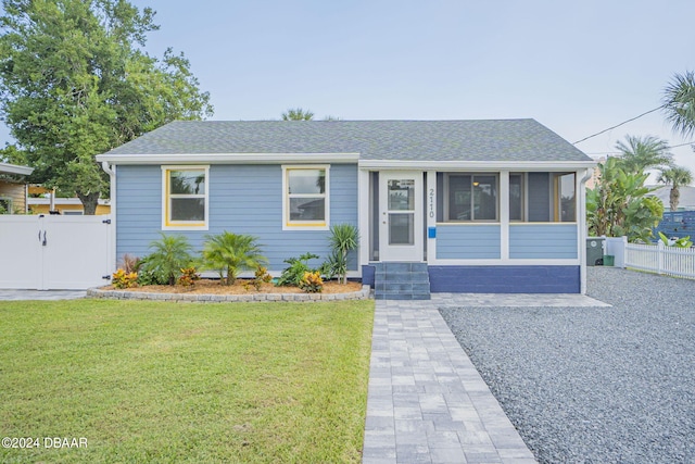 view of front facade featuring a front yard and a sunroom