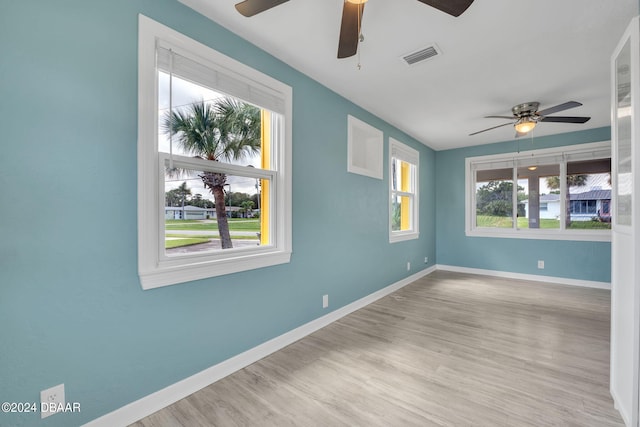 empty room featuring light hardwood / wood-style floors, a healthy amount of sunlight, and ceiling fan