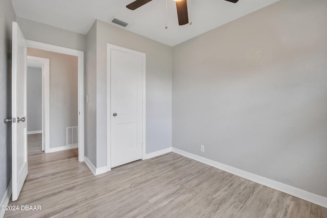 unfurnished bedroom featuring light wood-type flooring, ceiling fan, and a closet