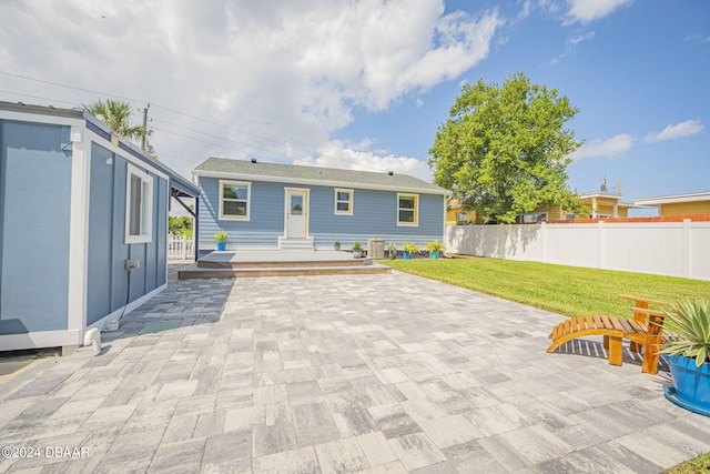 rear view of house with a lawn and a patio