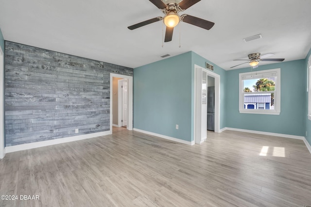 empty room with ceiling fan and light wood-type flooring