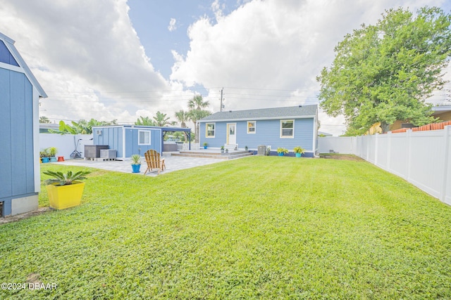 view of yard featuring a storage unit, cooling unit, and a patio