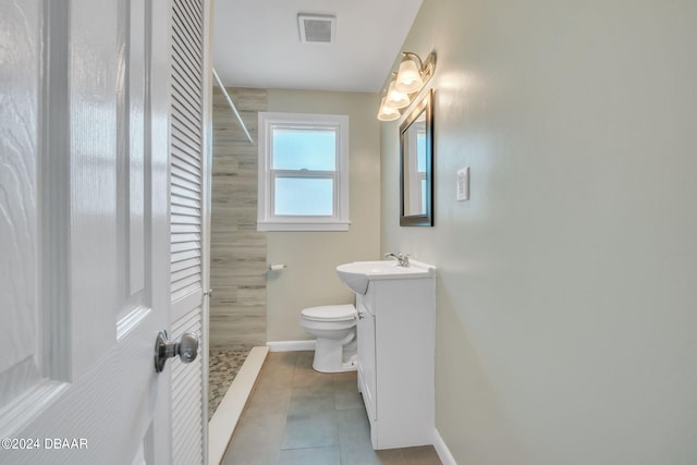 bathroom with walk in shower, tile patterned flooring, vanity, and toilet