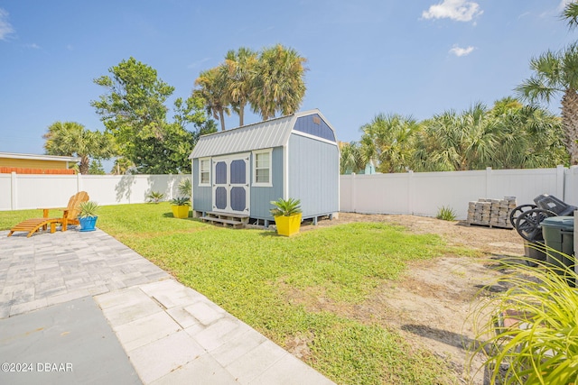 view of yard featuring a shed and a patio