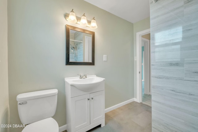 bathroom featuring toilet, a shower, vanity, and tile patterned floors