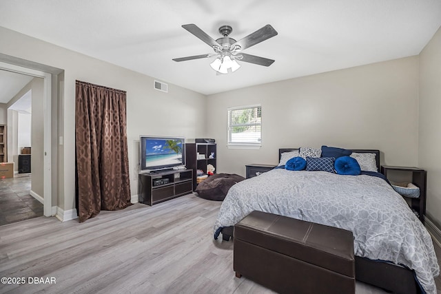 bedroom featuring a ceiling fan, baseboards, and light wood-style floors