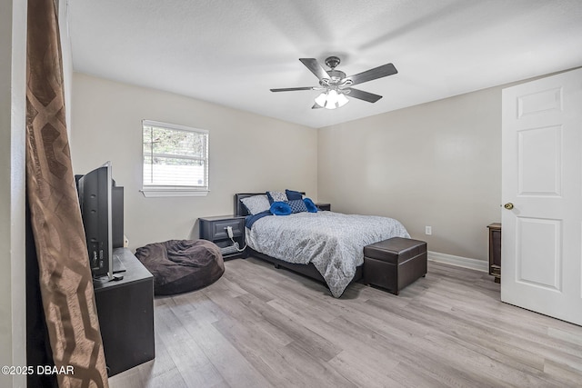 bedroom featuring light wood-style flooring, baseboards, and ceiling fan