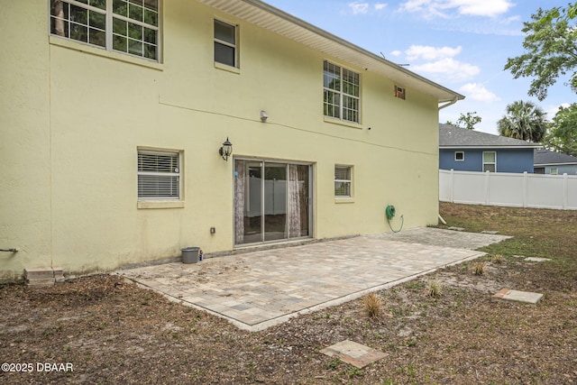 back of house with stucco siding, a patio area, and fence