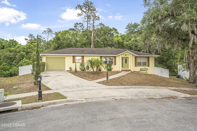 ranch-style house featuring driveway, a garage, stucco siding, and fence