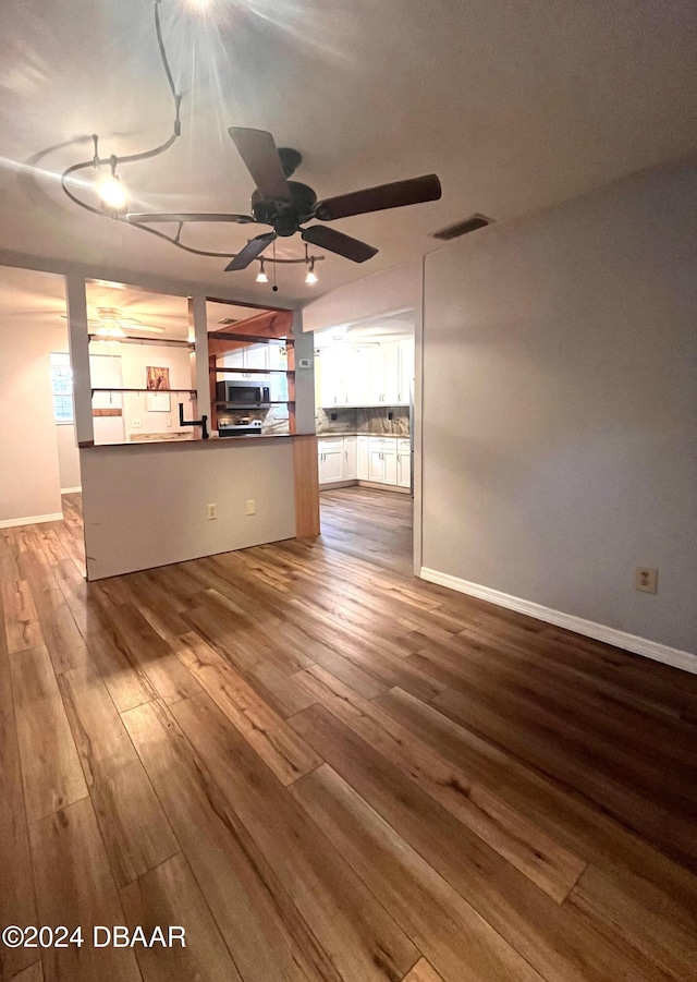 unfurnished living room featuring hardwood / wood-style flooring and ceiling fan