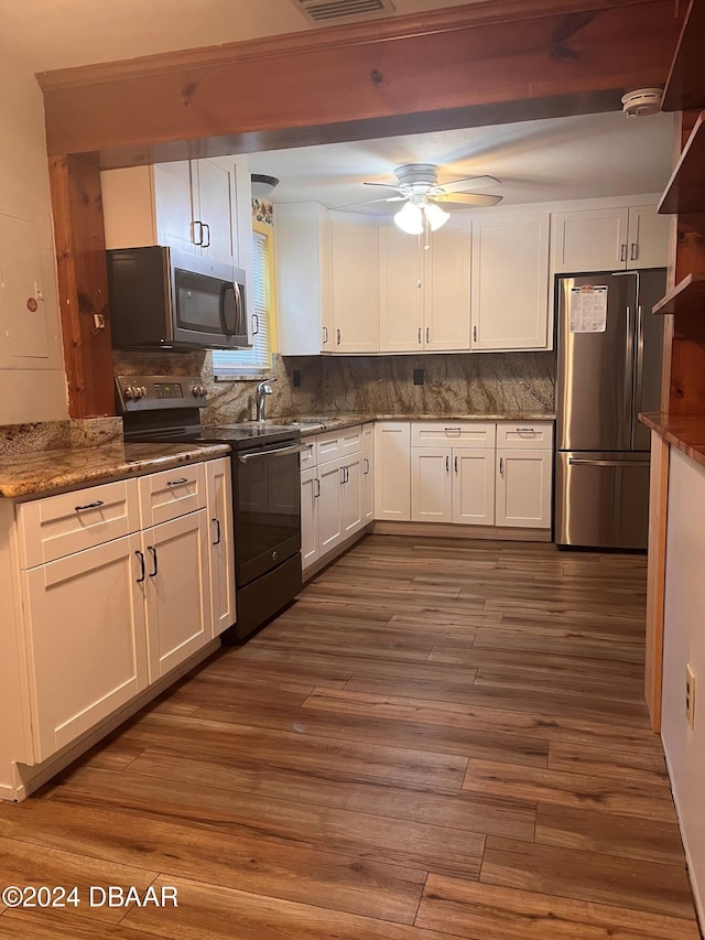 kitchen featuring dark hardwood / wood-style flooring, backsplash, appliances with stainless steel finishes, and white cabinets