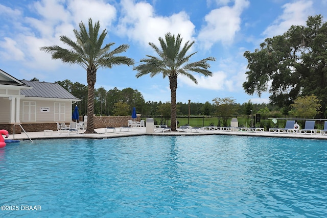 pool with a patio and fence