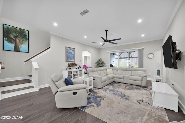 living area with stairway, wood finished floors, visible vents, and ornamental molding