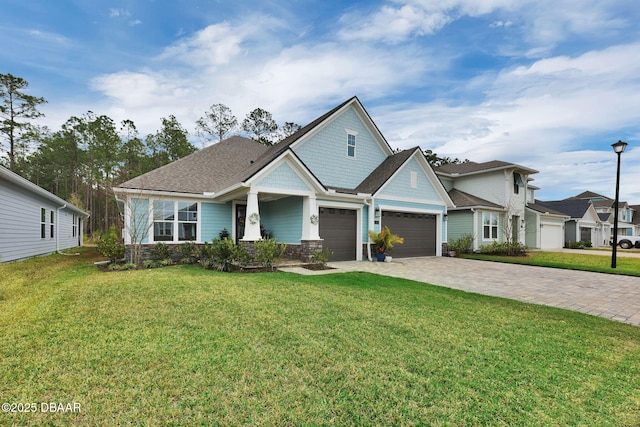 view of front of home with decorative driveway, an attached garage, and a front yard