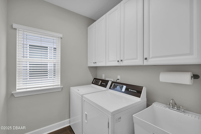 washroom with washer and clothes dryer, a healthy amount of sunlight, cabinet space, and a sink