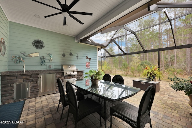 sunroom / solarium with a ceiling fan and a sink