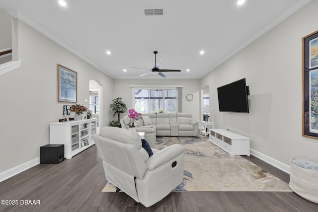 living area with visible vents, wood finished floors, and ornamental molding