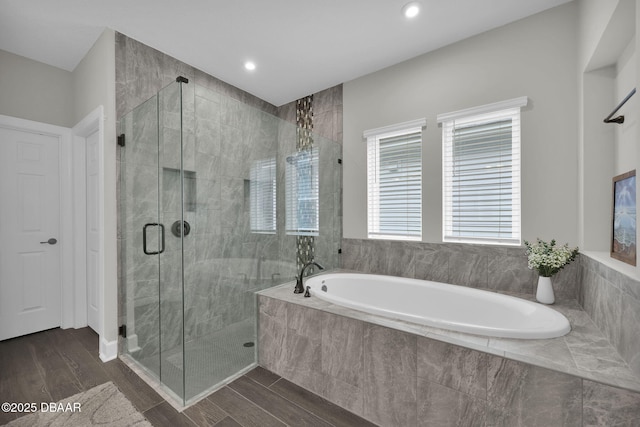 bathroom with a garden tub, recessed lighting, wood finished floors, and a stall shower