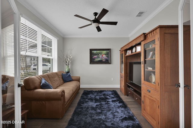 living room with visible vents, a textured ceiling, wood finished floors, crown molding, and baseboards