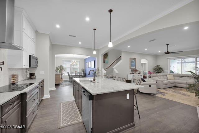 kitchen with visible vents, a sink, dishwasher, black electric stovetop, and wall chimney exhaust hood