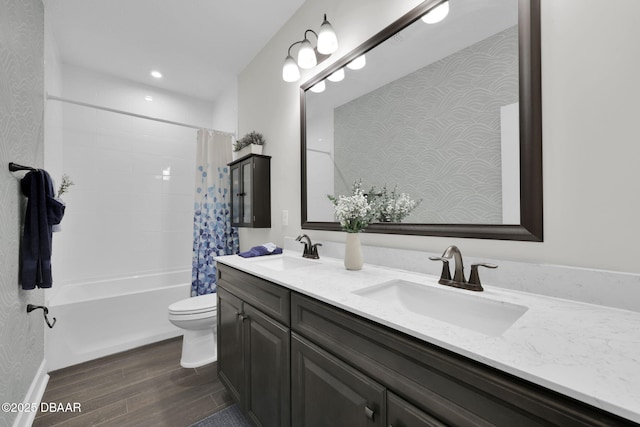 full bathroom featuring double vanity, toilet, wood finished floors, and a sink