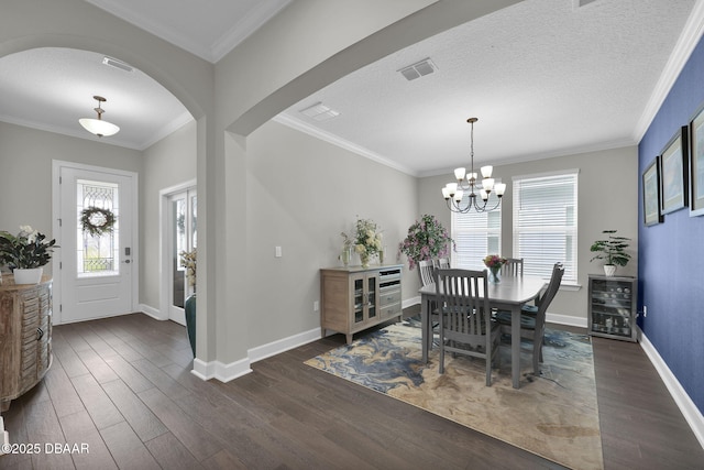 dining space with dark wood-type flooring, crown molding, arched walkways, and visible vents