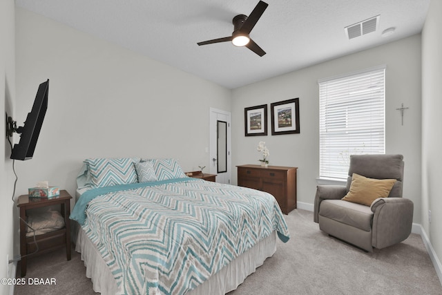 carpeted bedroom featuring visible vents, a textured ceiling, a ceiling fan, and baseboards