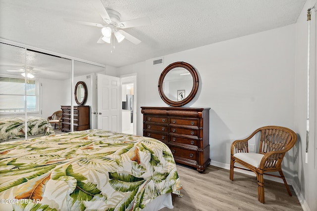 3370 Ocean Shore Blvd Unit 404B, Ormond Beach, FL 32176 - bedroom featuring baseboards, light wood-style floors, a textured ceiling, a closet, and ceiling fan