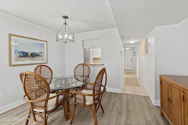 3370 Ocean Shore Blvd Unit 404B, Ormond Beach, FL 32176 - dining room featuring light wood-style floors, a textured ceiling, a chandelier, baseboards, and ornamental molding