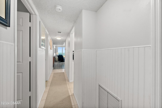 3370 Ocean Shore Blvd Unit 404B, Ormond Beach, FL 32176 - hallway featuring a textured ceiling and light tile patterned flooring